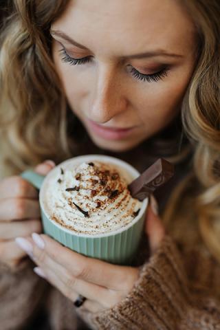 woman drinking mug of hot chocolate