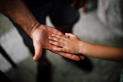 child's hand in adult hand