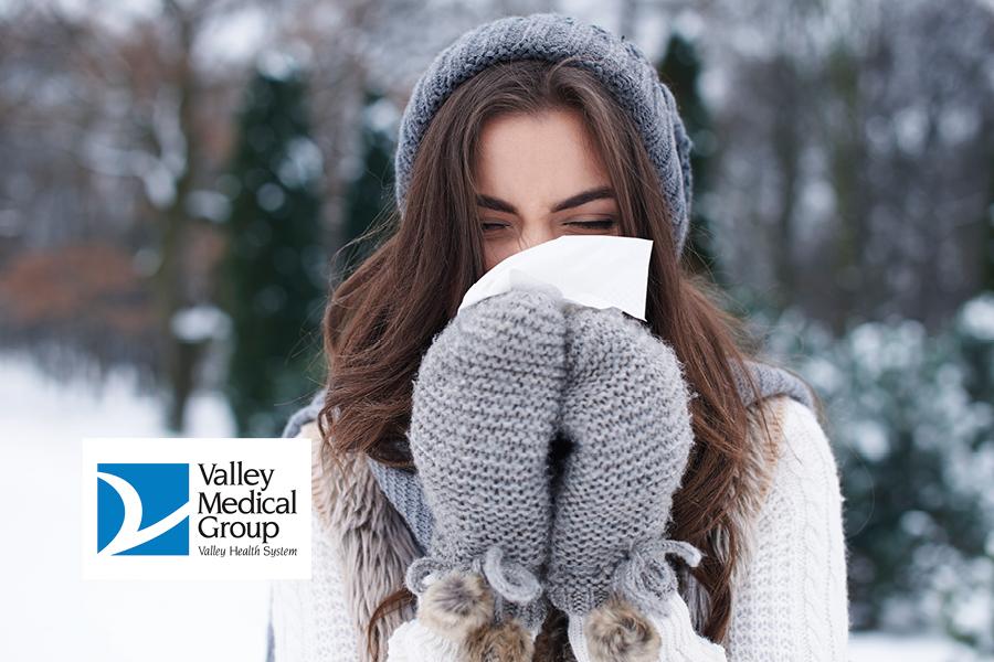 Woman blowing nose outside in winter